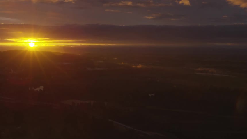 The sun sets over the horizon in an orange and blue sky