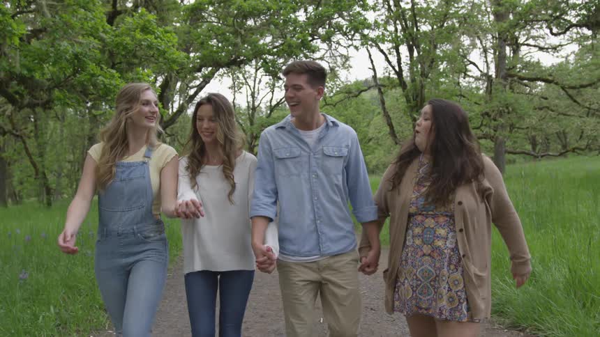Four people walking and holding hands