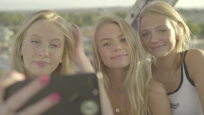 Three blonde girls taking selfie on a sunny day outdoors