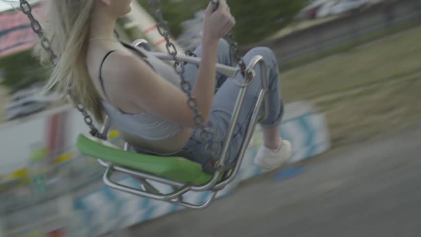 A woman on a carnival ride swinging around in a circle in the air