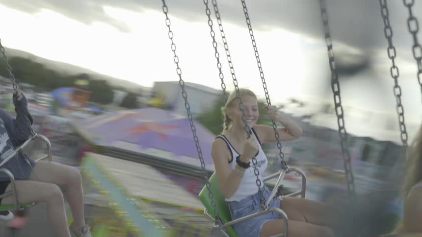 Girls ride on twirling carnival ride