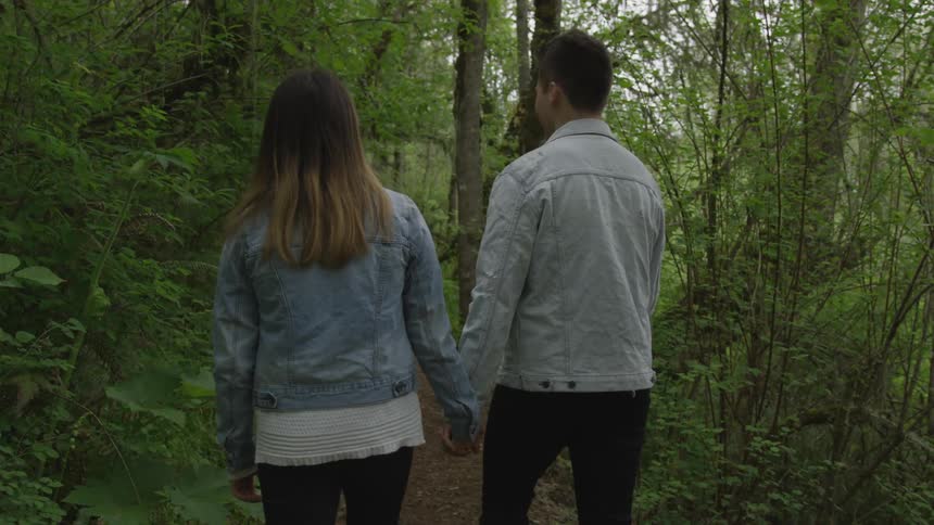 A couple holding hands on a trail