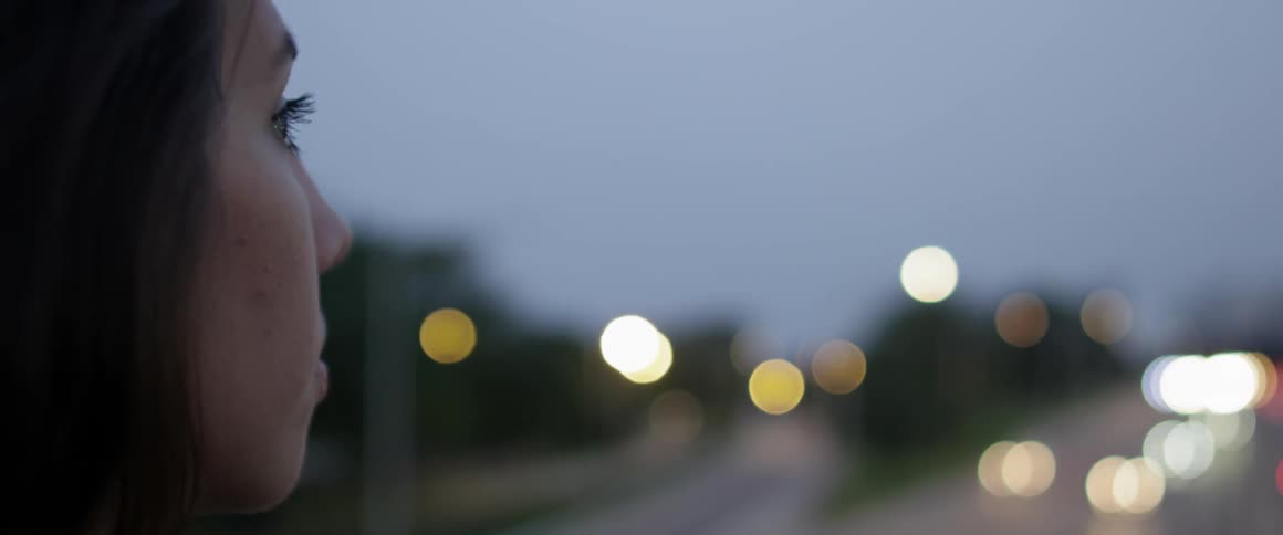 Young woman watches cars on a highway