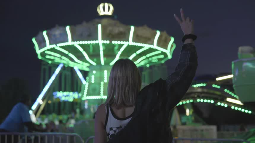 Woman shows the peace sign to people on a ride