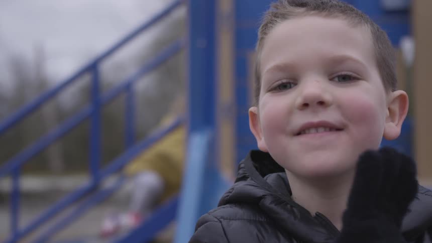 Young boy smiling and waving
