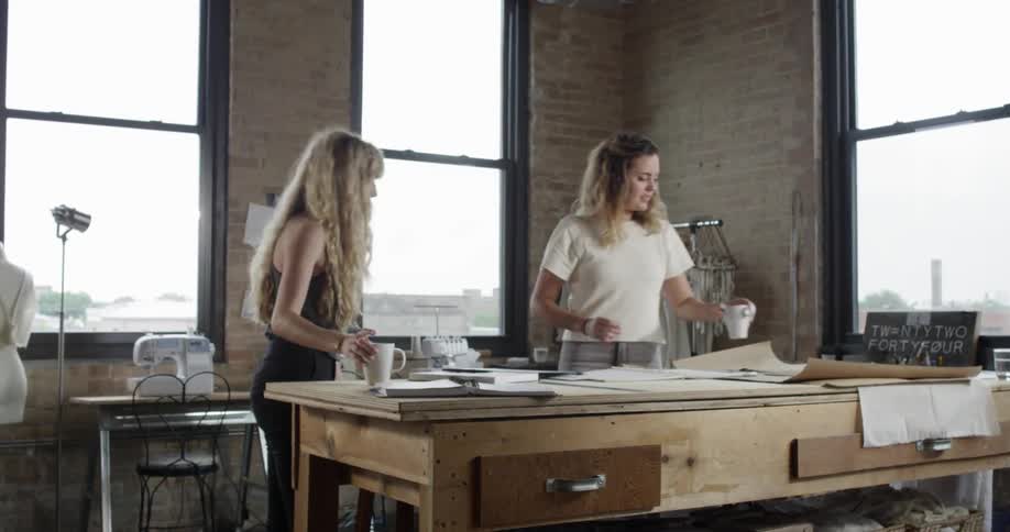 Two woman walking towards a table