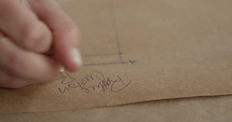 A person writing with a pen on some paper