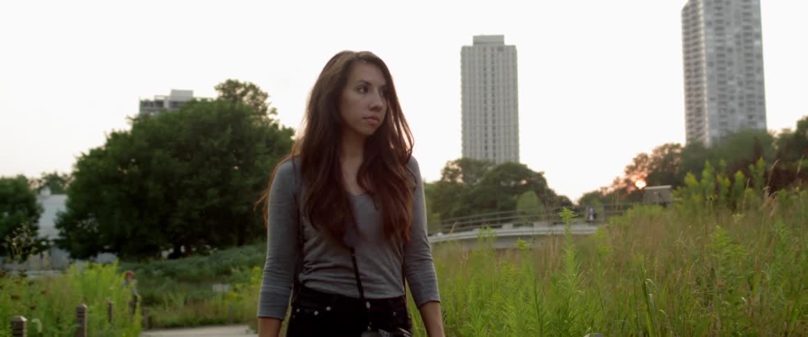 A woman is walking through a park