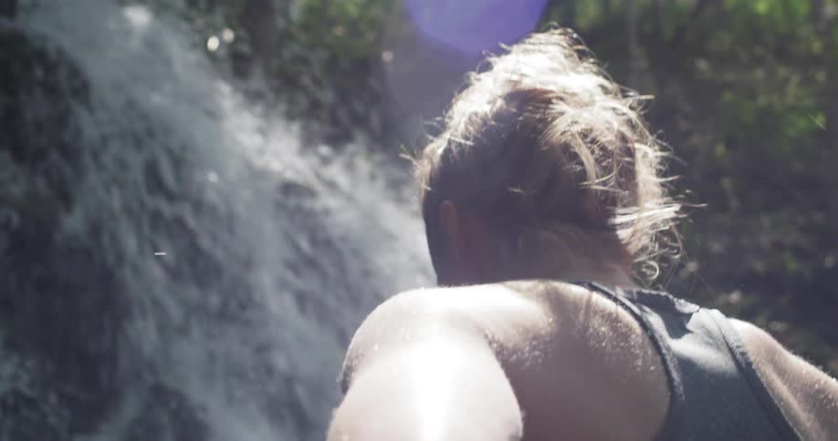 A woman is looking at a waterfall