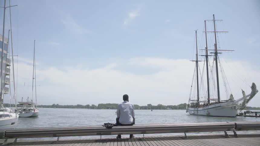 A man sitting by the marina