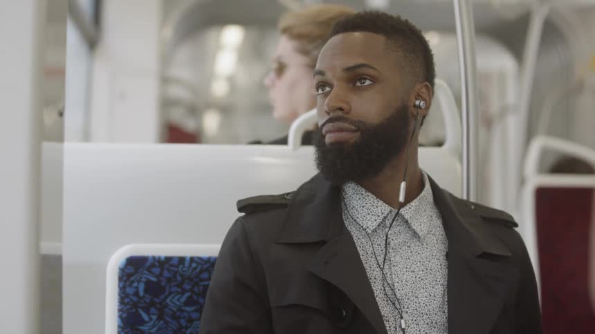 A man looking around while sitting on the bus