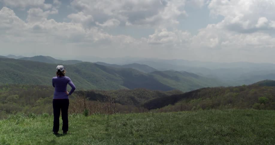 A woman overlooks a mountain range