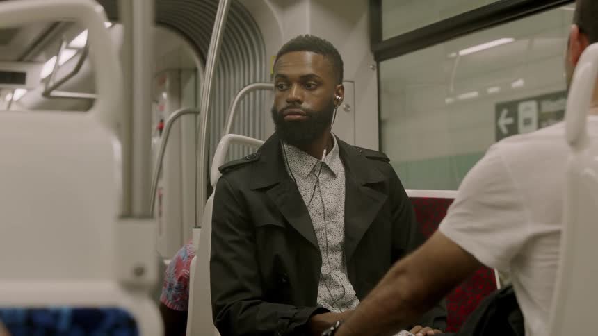 Black man on a bus looking around