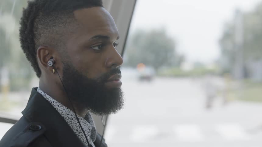 A man is in a car with headphones in