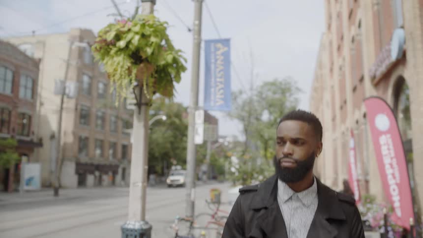 Young black man walks down city street