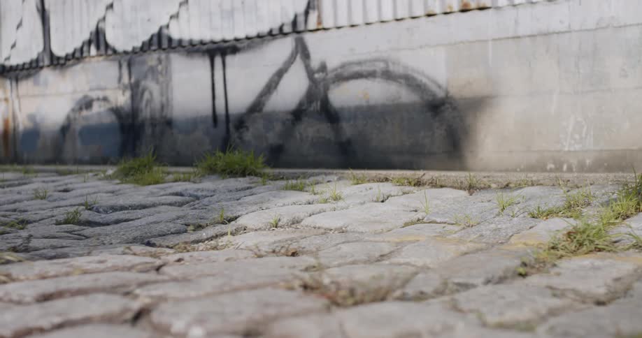 Two people walk along cobbled street