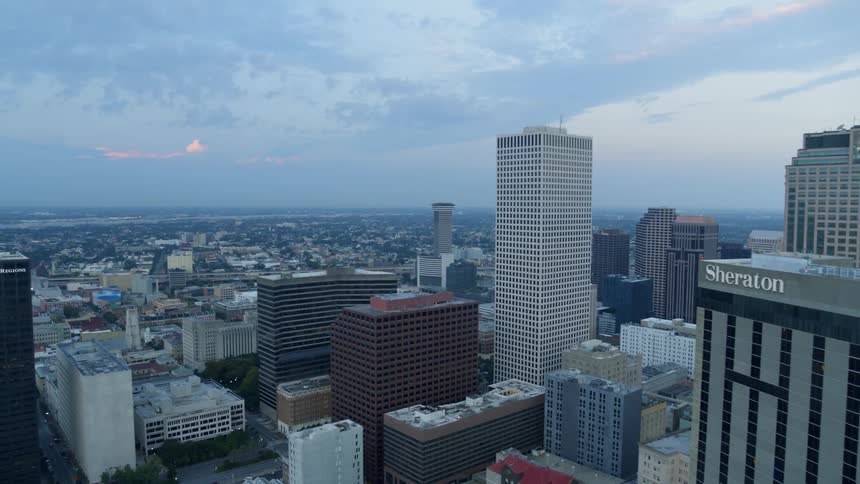 Camera flies over a large city looking towards the horizon