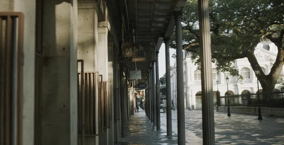 People walk in distance of historic looking city block