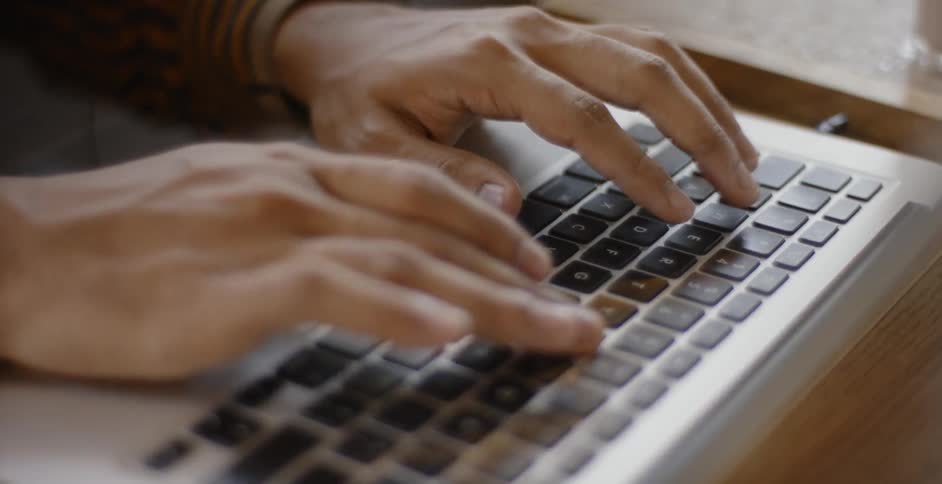 A man is typing on a computer