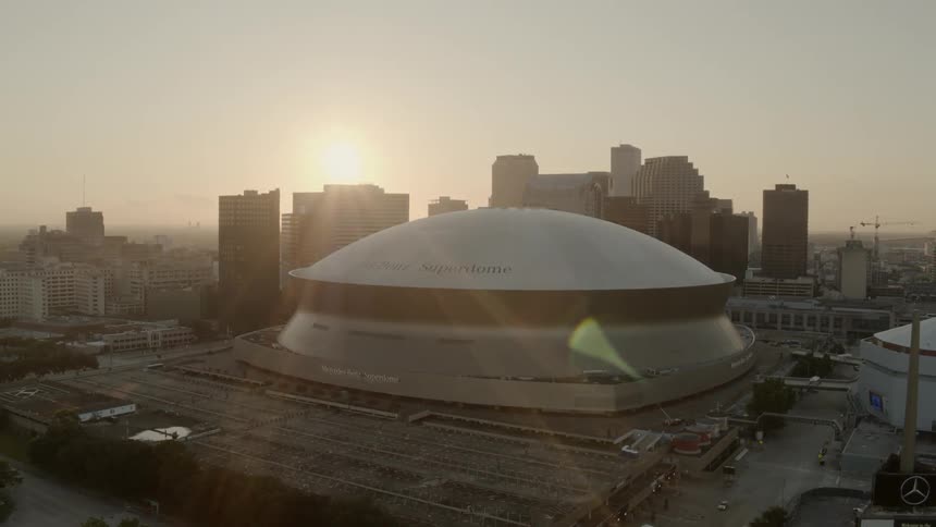 A city with a large stadium in the center of the buildings