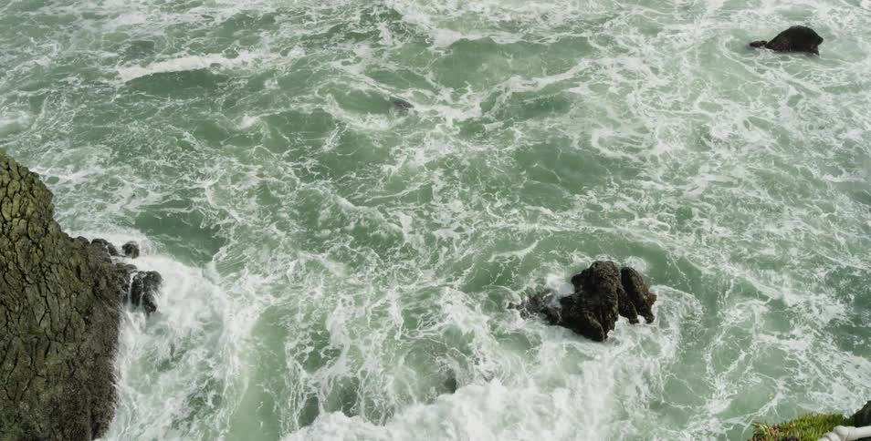 Ocean waves crash against rocks