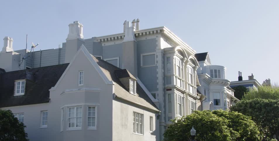 Steep street with large row houses and trees