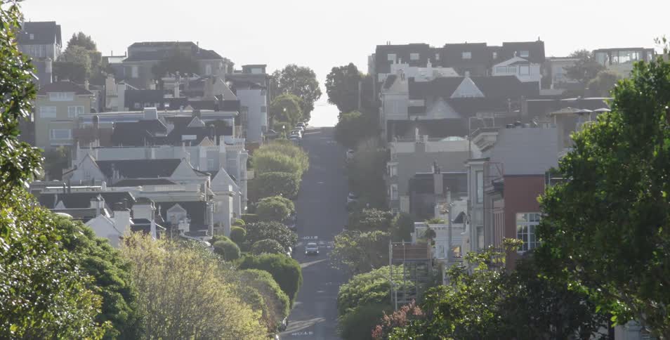 A wide street through a neighborhood during the day