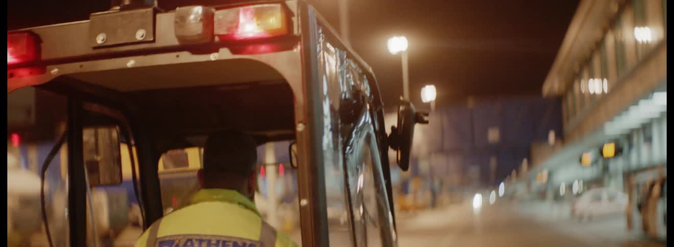 A worker at athens international airport drives a vehicle at night