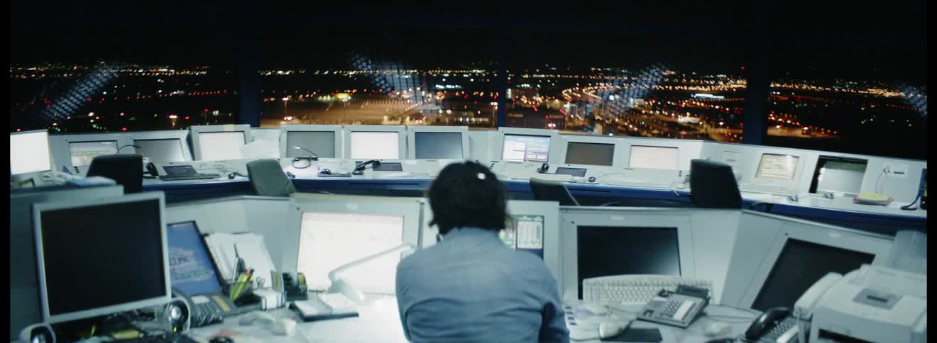 Woman at a desk with computers and answers phone