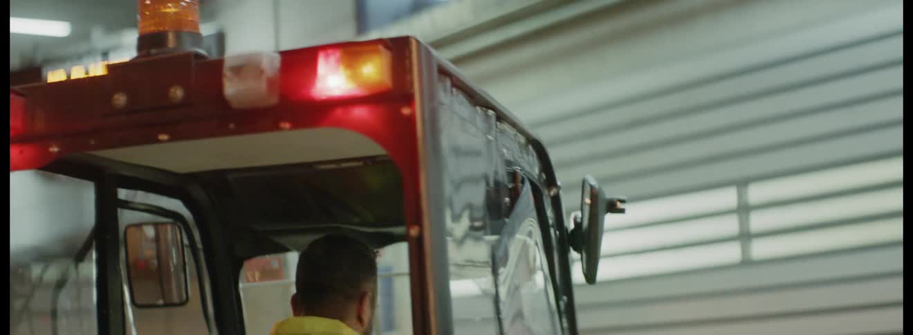 A man driving a small construction style vehicle