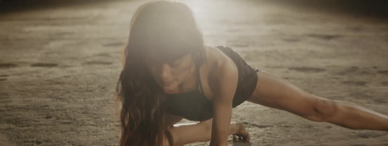 Woman dancing on a concrete floor inside a building