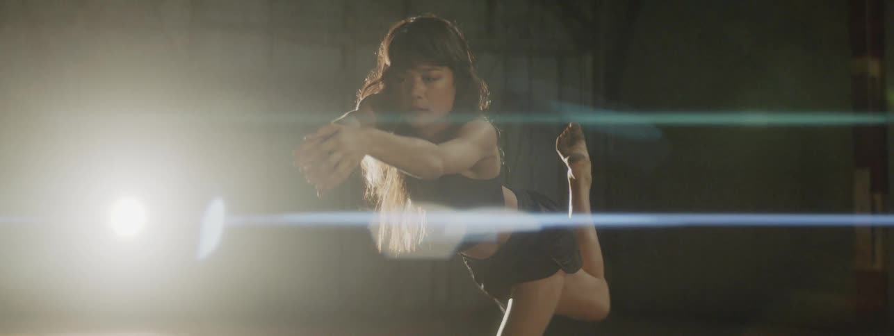 A woman dancing in an old warehouse