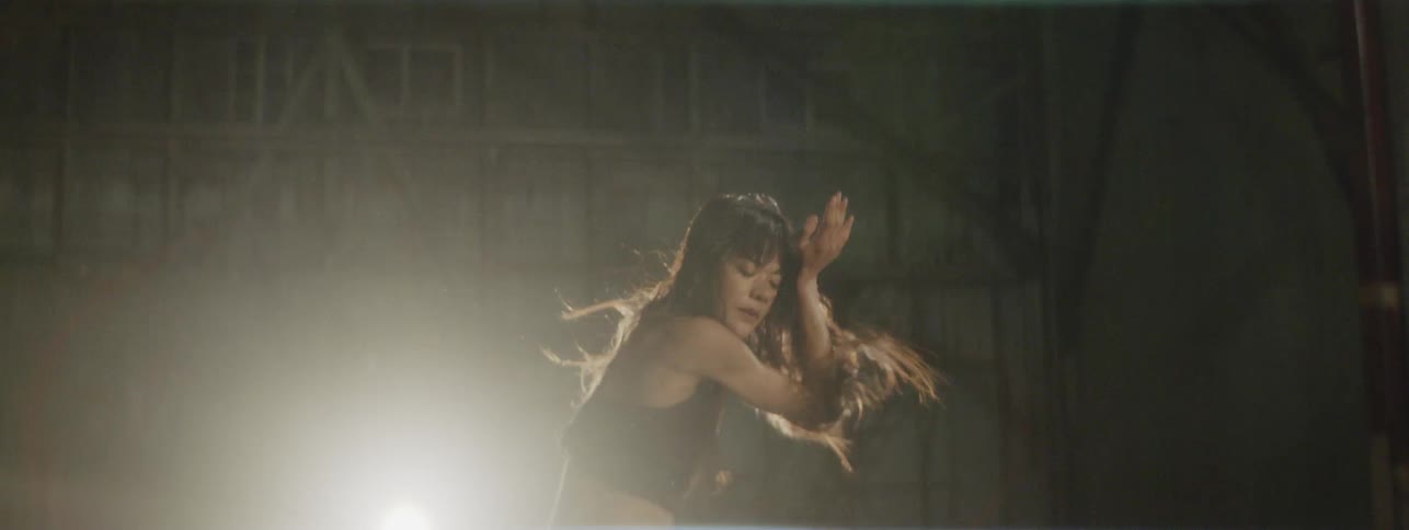 Woman dances in dim room
