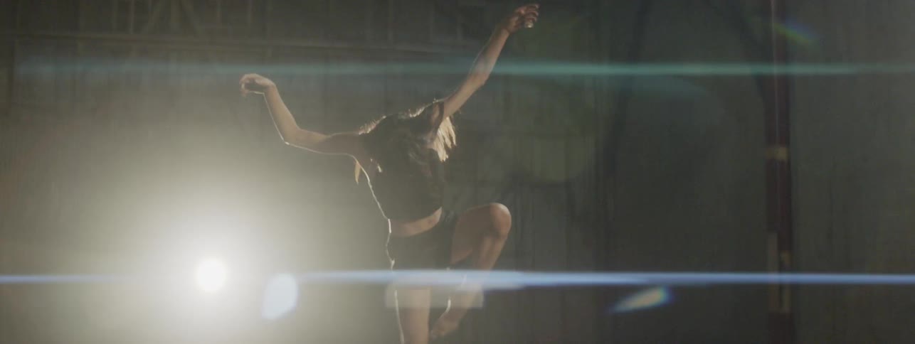 A female dancer dancing in an empty warehouse