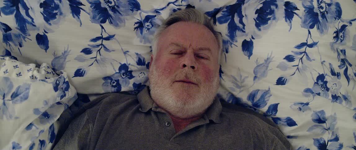 Man gets up from laying on bed