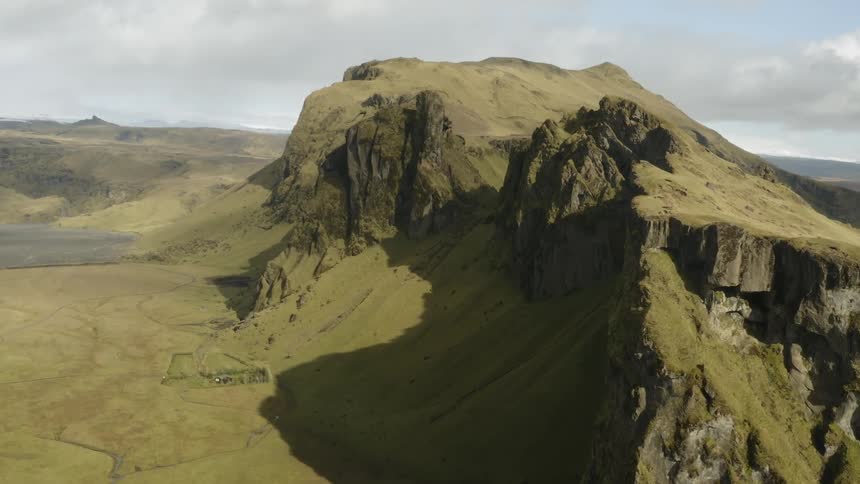 The sun shines on the tops of the brown cliffs