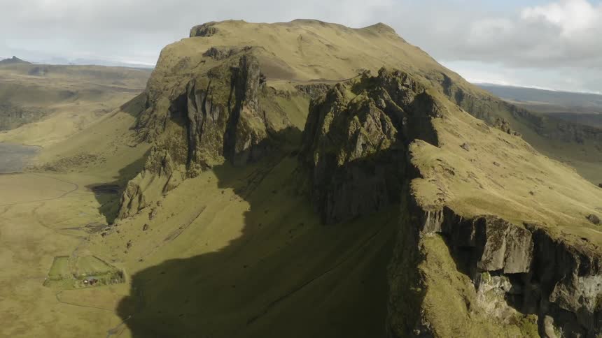 A plateau covered in grass rises from the plains