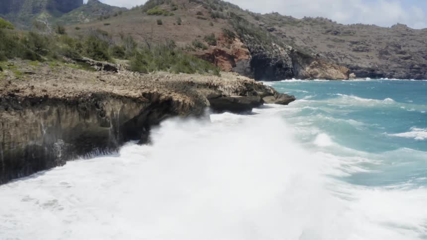 Ocean waves hit rocks making foam during the day
