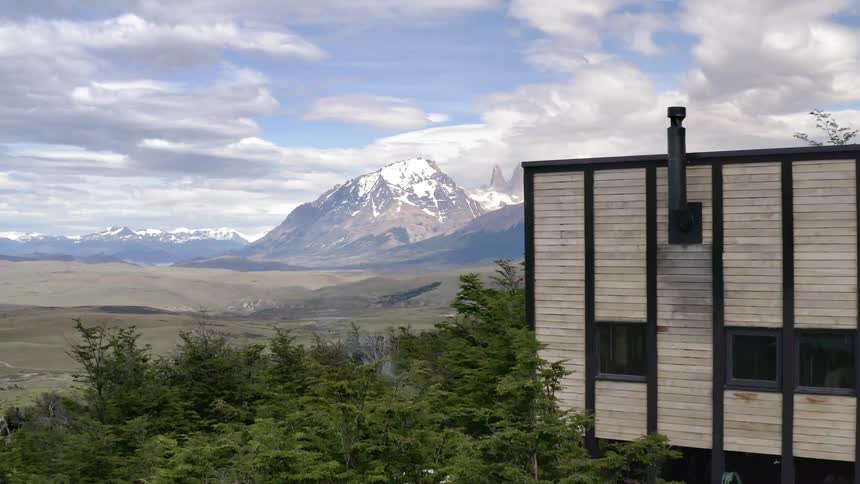 A contemporary home on a hillside overlooking snow capped mountains