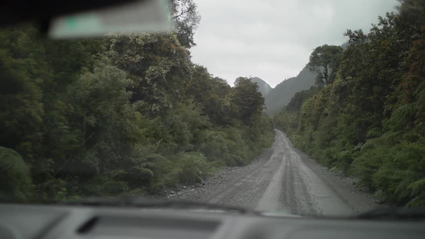 A vehicle driving down a dirt road