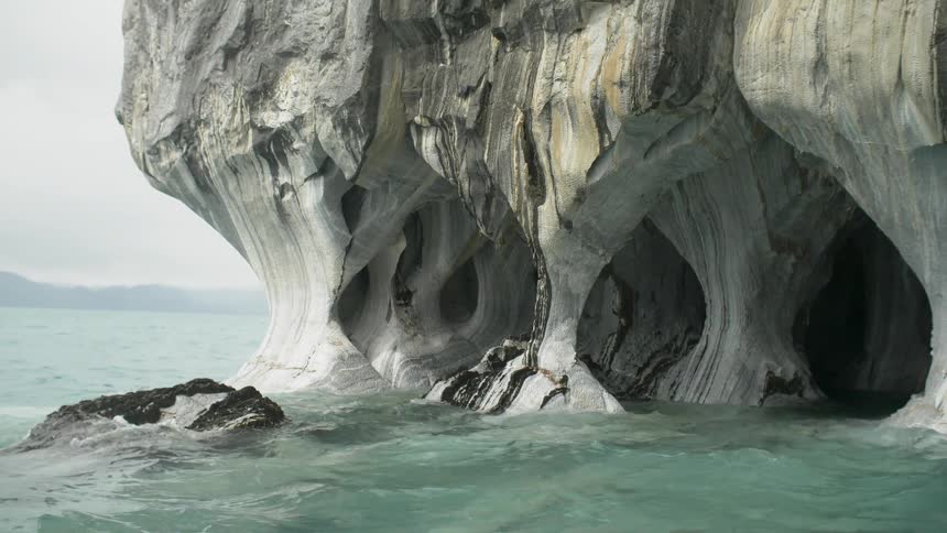 Water crashing against a large rock formation