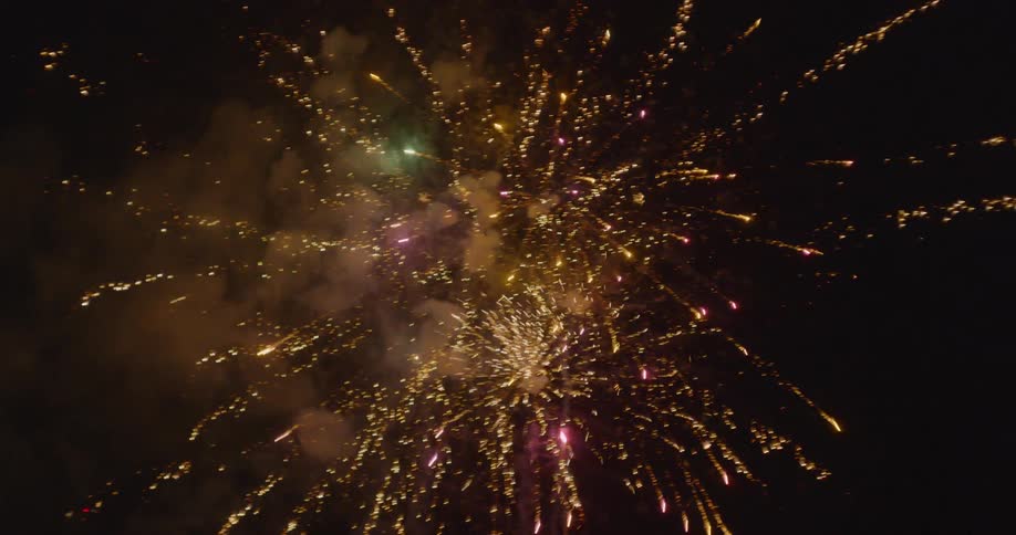 Fireworks exploding into sparkling lights at night time