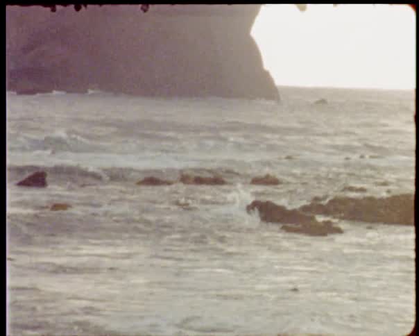 Small waves crashing in on the shore line over rocks on the coast