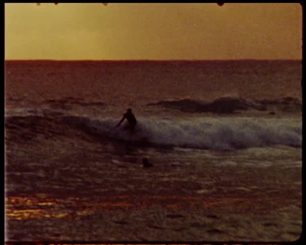 Surfer catching a wave at sunrise