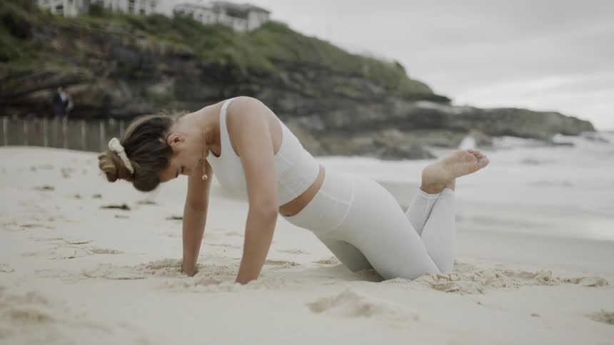 Woman doing push ups on beach