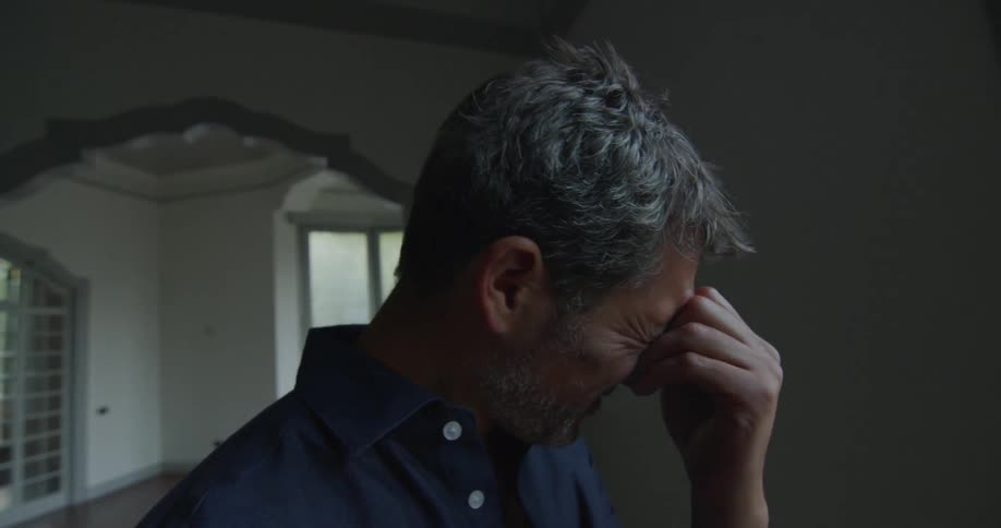 An upset man puts his hand to his face