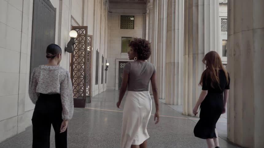 Three woman walking in front of a building
