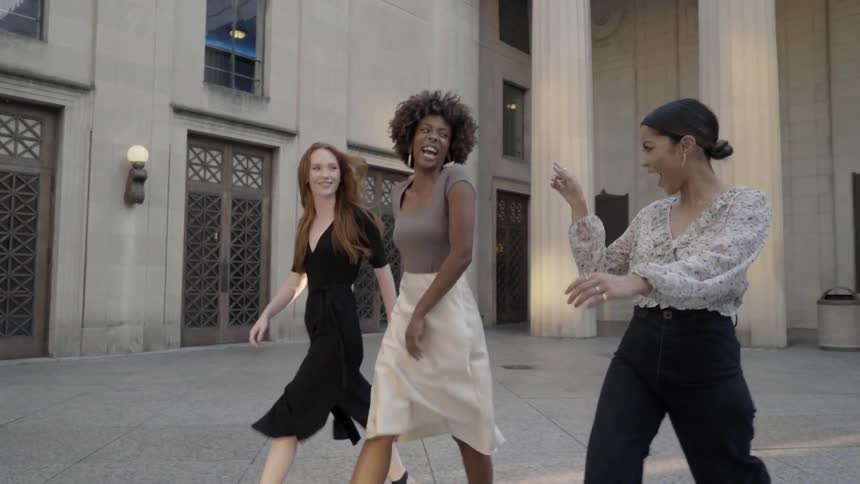 3 girls walking next to a building