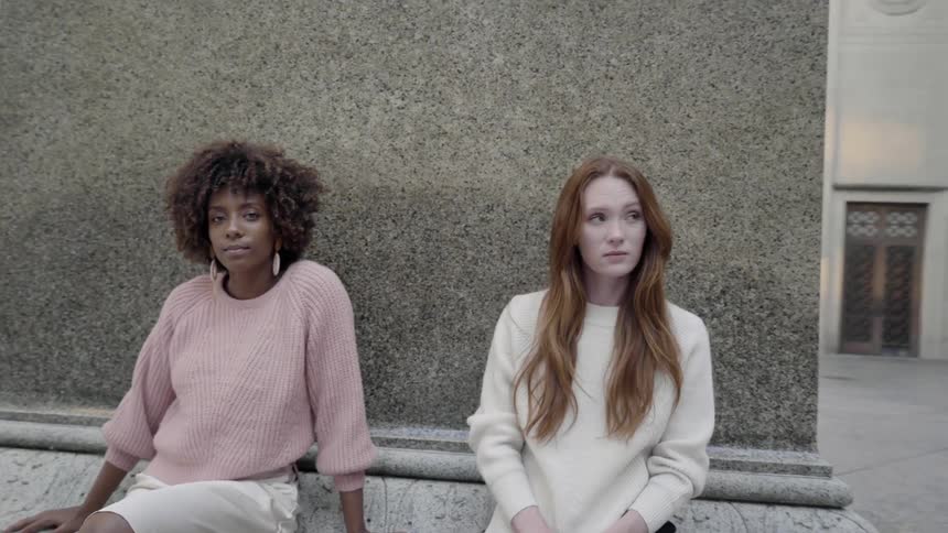 Two women sitting outside a courthouse