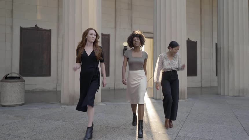 Three young women walk from government building